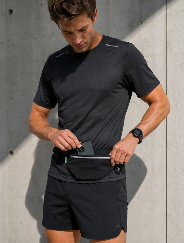 A runner wearing a TEMPO running belt while training outdoors